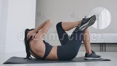 白人黑发女人躺在地毯上做腹肌锻炼。 每天在家锻炼身体，保持健康